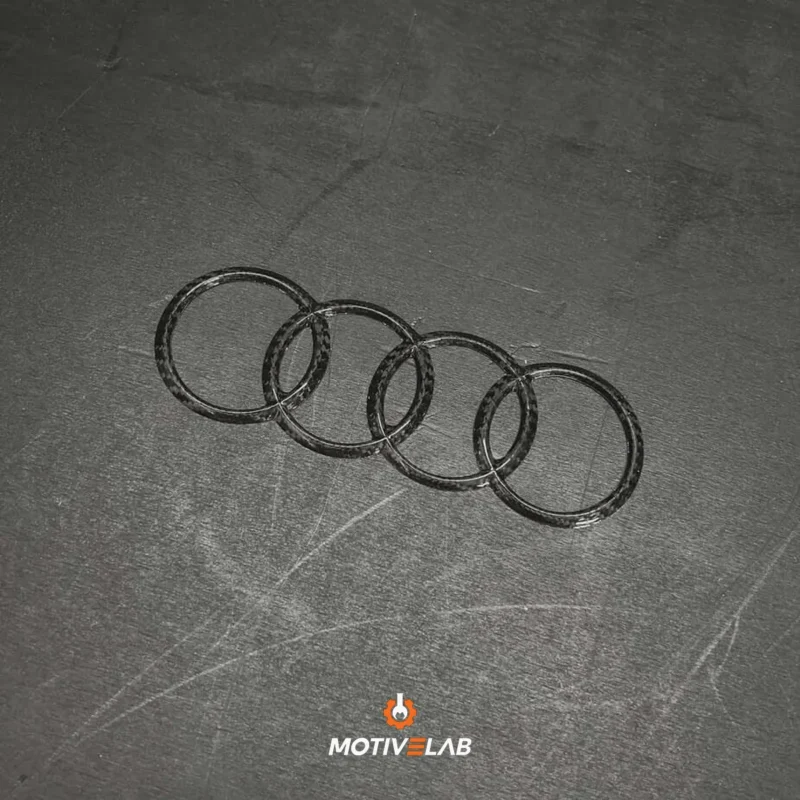 Audi carbon fibre badge featuring the Audi logo